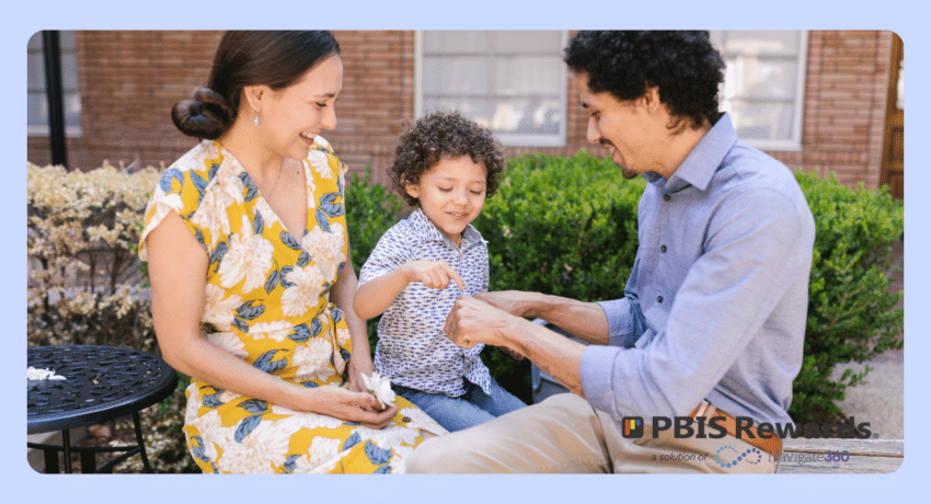 A young child happily playing with their parents outside.
